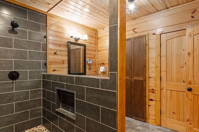 bathroom with wood ceiling, a tile shower, and wooden walls