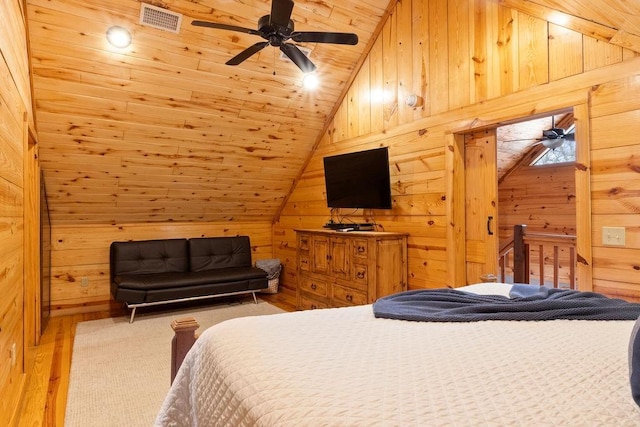 bedroom with lofted ceiling, wood ceiling, hardwood / wood-style flooring, wood walls, and ceiling fan