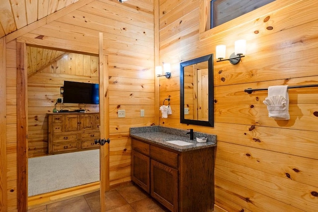 bathroom featuring tile patterned floors, vanity, and wooden walls