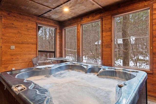 unfurnished sunroom featuring wooden ceiling and a hot tub