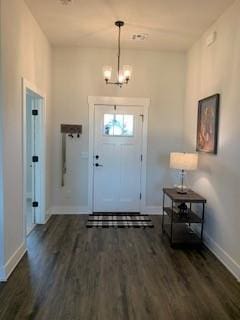 foyer with dark hardwood / wood-style flooring and an inviting chandelier