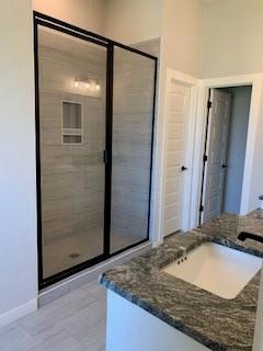 bathroom with tile patterned flooring, vanity, and a shower with shower door