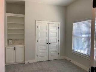 unfurnished bedroom with light carpet and a closet