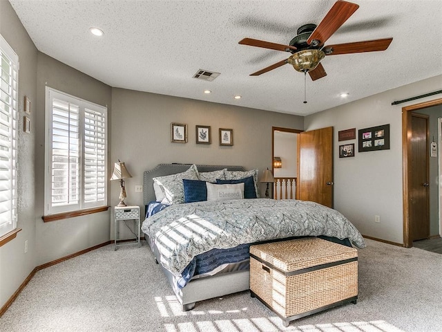 carpeted bedroom with a textured ceiling and ceiling fan