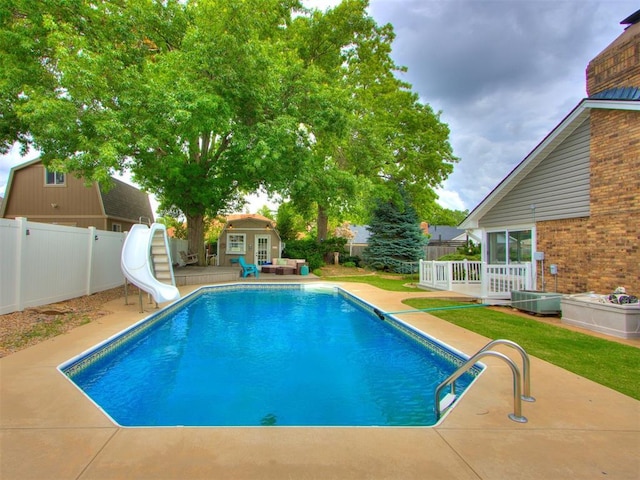 view of swimming pool featuring a storage shed and a water slide