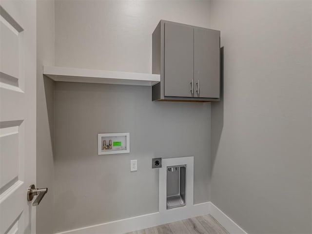 washroom with light wood-type flooring, cabinets, hookup for a washing machine, and hookup for an electric dryer