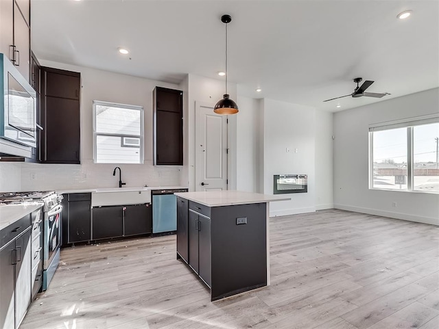 kitchen featuring a center island, a healthy amount of sunlight, appliances with stainless steel finishes, and a sink