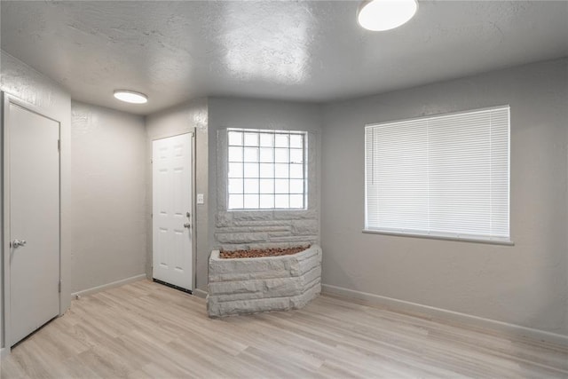 foyer featuring a textured ceiling and light wood-type flooring