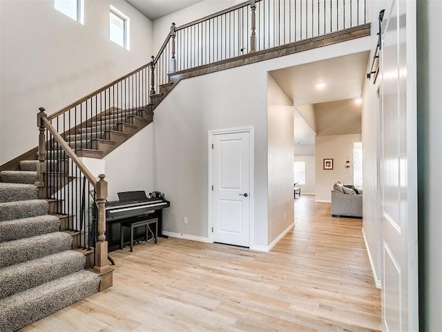 stairs with wood-type flooring and a towering ceiling