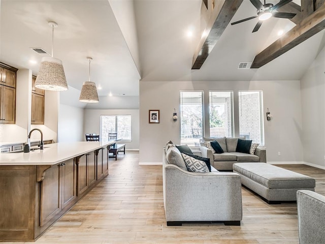 living room featuring ceiling fan, lofted ceiling with beams, and light hardwood / wood-style floors