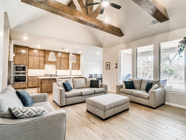 living room with ceiling fan, light hardwood / wood-style flooring, and high vaulted ceiling