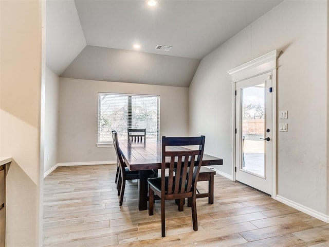 dining space with lofted ceiling and light hardwood / wood-style flooring