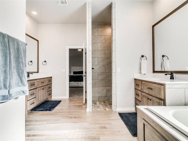 bathroom featuring ceiling fan, vanity, a bath, and hardwood / wood-style flooring