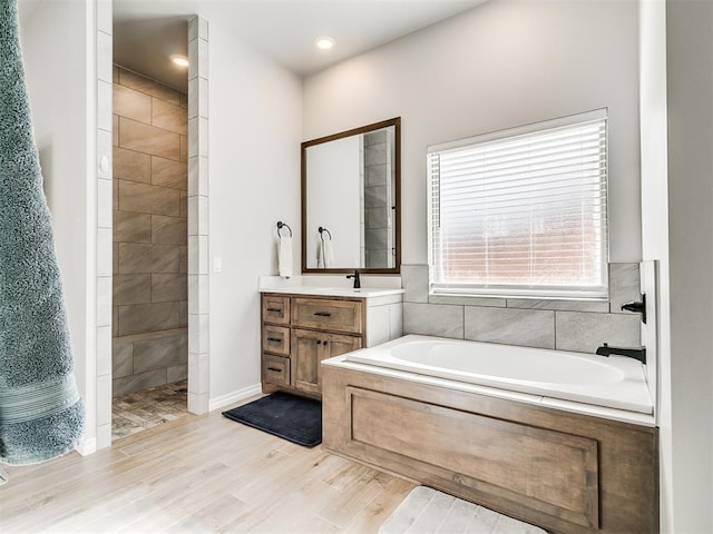 bathroom featuring separate shower and tub, vanity, and hardwood / wood-style flooring