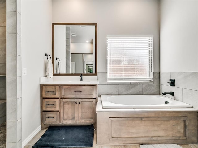 bathroom with vanity and a relaxing tiled tub