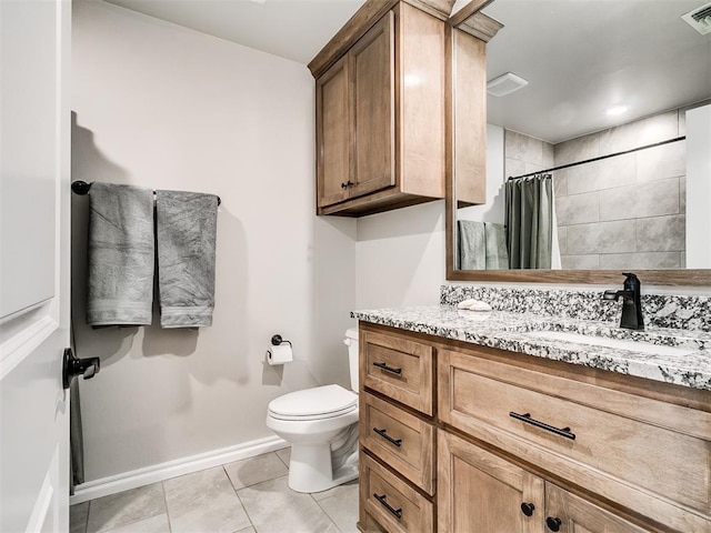 bathroom featuring toilet, vanity, tile patterned flooring, and walk in shower