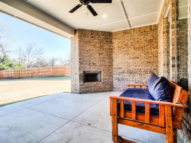 view of patio featuring ceiling fan and an outdoor brick fireplace