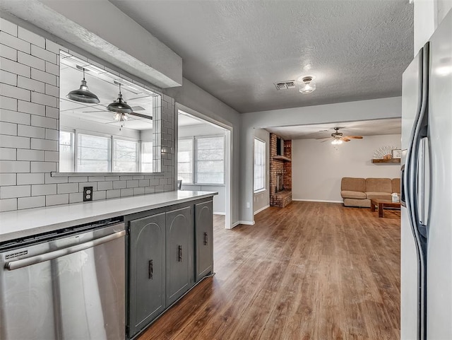 kitchen featuring stainless steel dishwasher, decorative light fixtures, decorative backsplash, gray cabinets, and fridge with ice dispenser