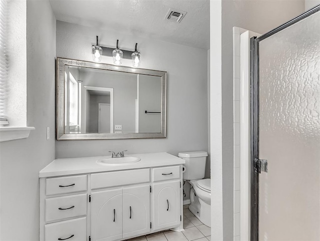 bathroom with walk in shower, vanity, tile patterned floors, and toilet