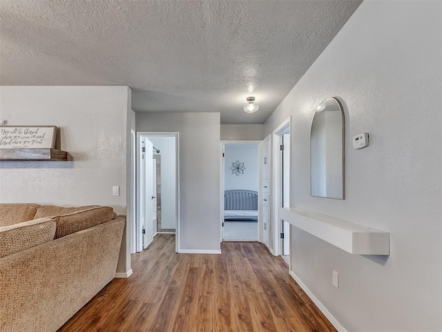 hallway featuring wood-type flooring and a textured ceiling