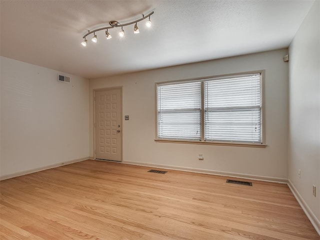 unfurnished room featuring plenty of natural light and light wood-type flooring