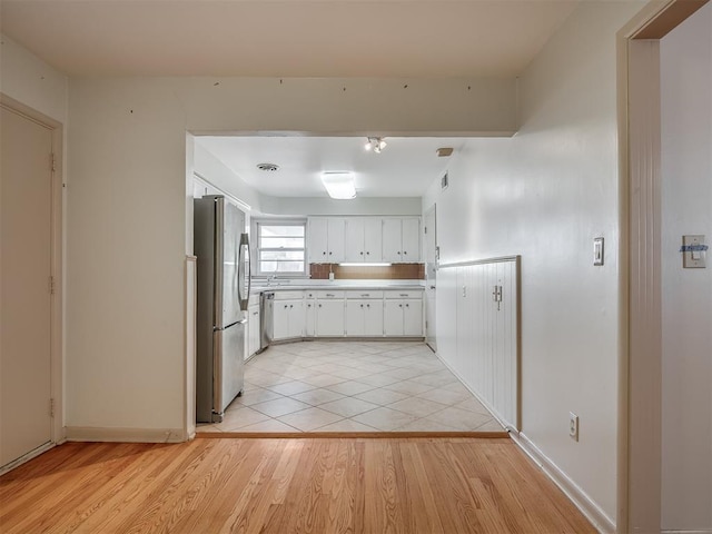 kitchen featuring light hardwood / wood-style flooring, white cabinets, and appliances with stainless steel finishes