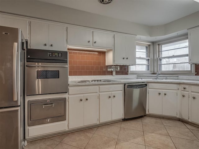 kitchen with white cabinets, light tile patterned flooring, sink, and appliances with stainless steel finishes