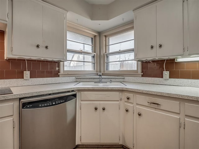 kitchen featuring backsplash, sink, white cabinets, and stainless steel dishwasher