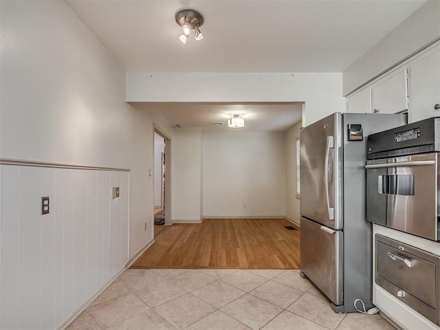 kitchen with white cabinets, appliances with stainless steel finishes, and light tile patterned flooring