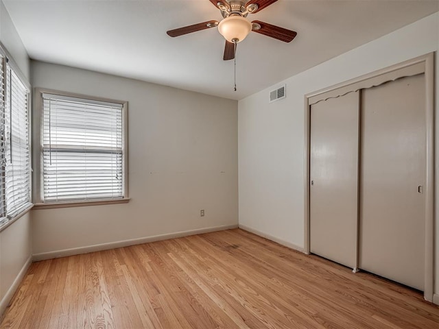 unfurnished bedroom with a closet, light hardwood / wood-style flooring, and ceiling fan