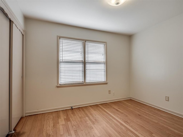 unfurnished bedroom with light hardwood / wood-style flooring and a closet