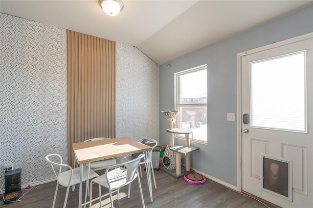 dining area with wood-type flooring and vaulted ceiling