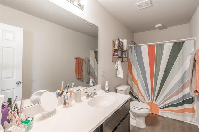 bathroom featuring a shower with curtain, toilet, vanity, and hardwood / wood-style flooring