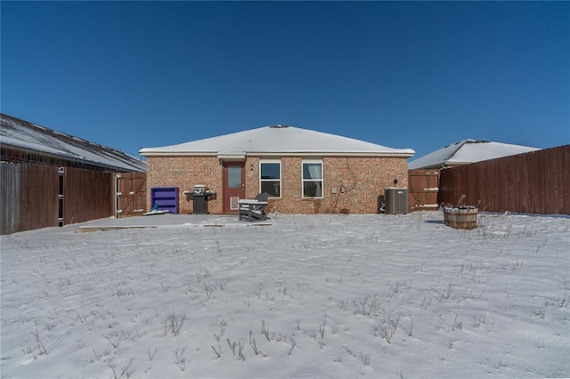 snow covered rear of property with cooling unit