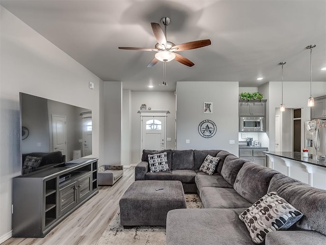 living room featuring ceiling fan and light wood-type flooring