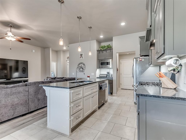 kitchen featuring sink, decorative light fixtures, ceiling fan, a kitchen island with sink, and appliances with stainless steel finishes