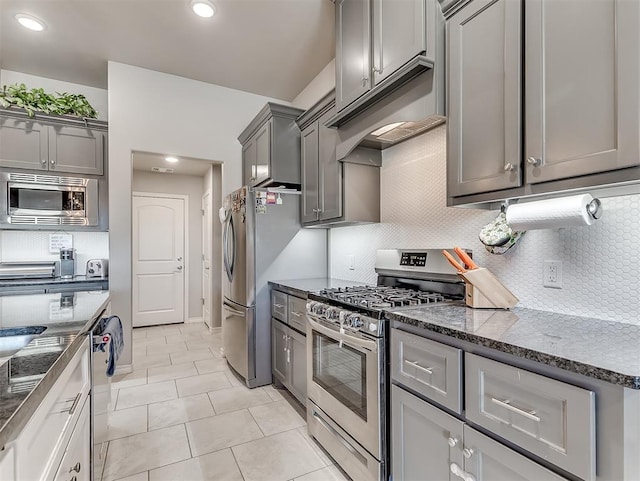 kitchen featuring appliances with stainless steel finishes, gray cabinetry, decorative backsplash, and light tile patterned floors