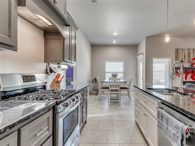 kitchen featuring stainless steel appliances, sink, white cabinetry, custom range hood, and backsplash