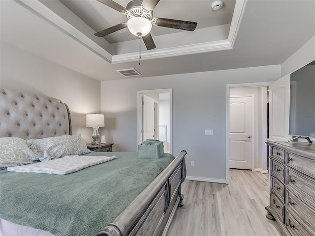 bedroom featuring a raised ceiling, ceiling fan, and light hardwood / wood-style flooring