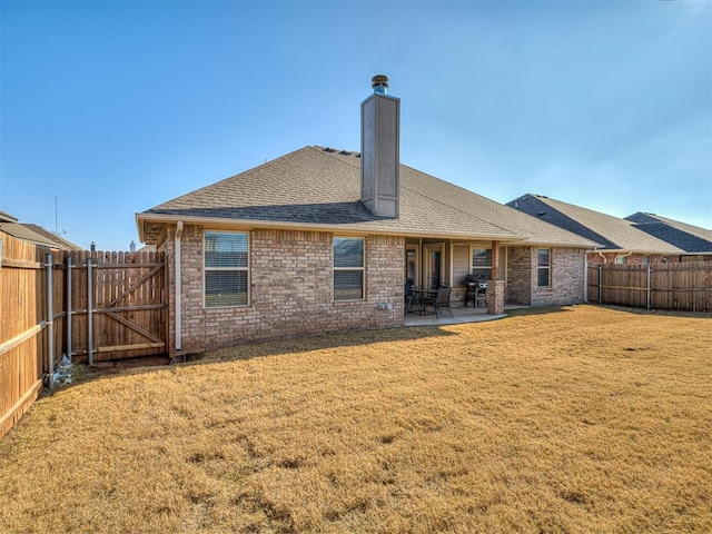 back of house with a lawn and a patio