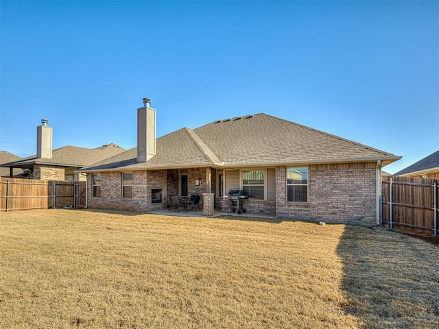 rear view of property with a patio and a yard