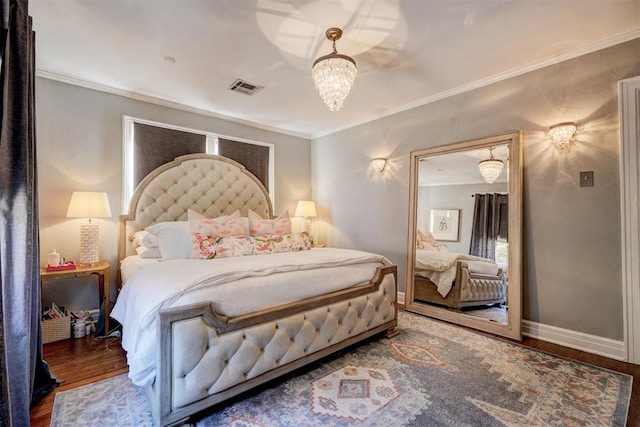 bedroom with ornamental molding, hardwood / wood-style floors, and a chandelier