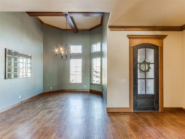 foyer featuring ornamental molding, a notable chandelier, beam ceiling, hardwood / wood-style floors, and a high ceiling