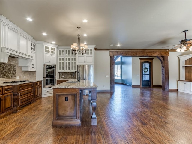 kitchen featuring pendant lighting, sink, a breakfast bar, appliances with stainless steel finishes, and a kitchen island with sink