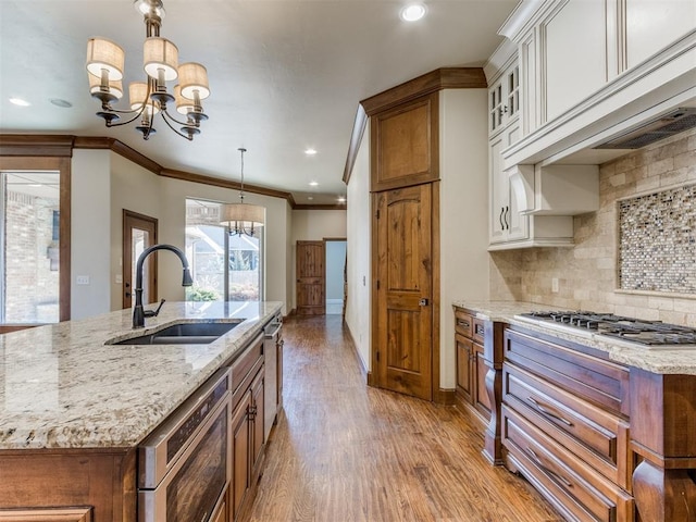 kitchen with white cabinetry, sink, pendant lighting, and a chandelier