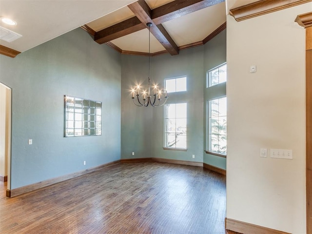 unfurnished room featuring hardwood / wood-style flooring, a towering ceiling, coffered ceiling, a notable chandelier, and beamed ceiling