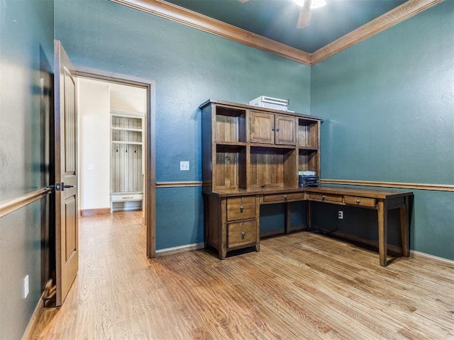 unfurnished office with ornamental molding, hardwood / wood-style floors, ceiling fan, and built in desk