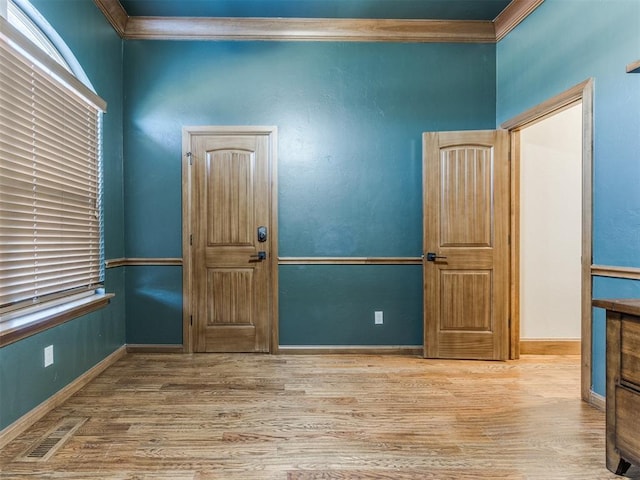 spare room with crown molding, light hardwood / wood-style flooring, and plenty of natural light