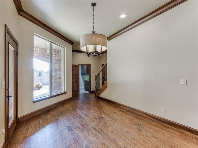 interior space featuring crown molding, wood-type flooring, and a notable chandelier