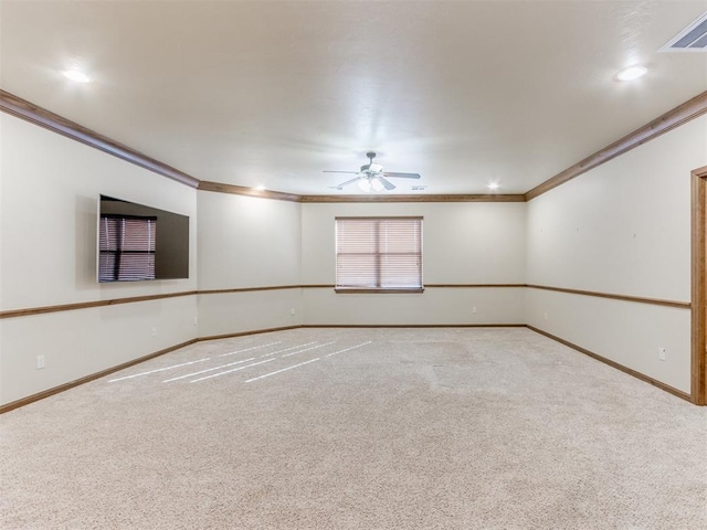 spare room with crown molding, light colored carpet, and ceiling fan